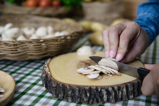 Lady cooks fresh champignon mushroom vegetable in the kitchen - people with vegetable cooking concept