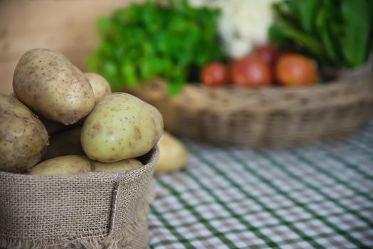 Fresh potato ready for cooking with potato sack background - potato cooking concept