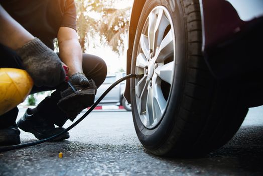 Technician is inflate car tire - car maintenance service transportation safety concept