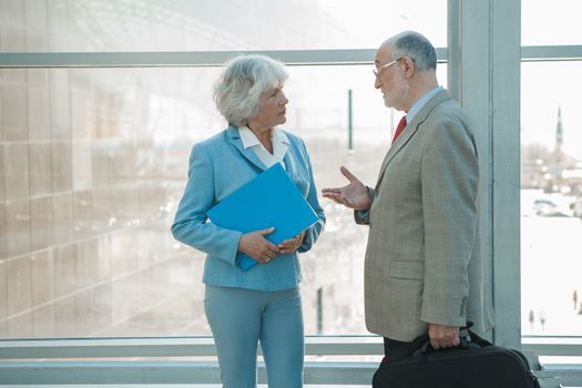 Senior business colleagues man and woman having conversation at work