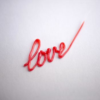 red the writing love drawn by 3d pen on white background
