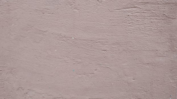 A fragment of a wall covered with stucco and painted in gray.