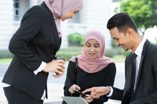 Muslim business people discussion with laptop, outdoor. 