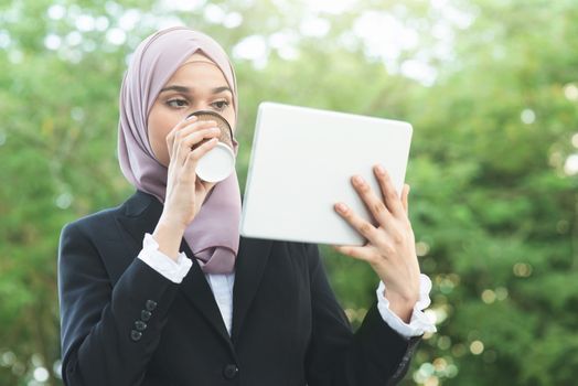 Muslim business woman drinking coffee while going to work in morning.