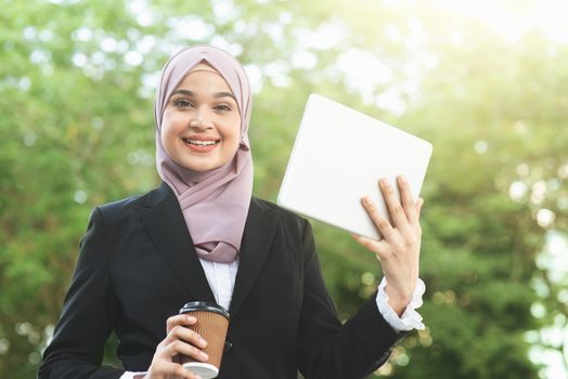 Muslim business woman drinking coffee while going to work in morning.