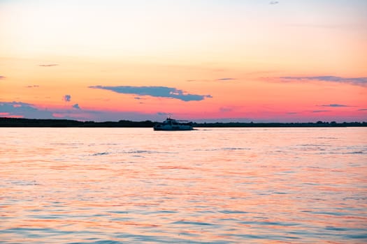 Sunset on the embankment of the Amur river in Khabarovsk. The sun set over the horizon. The embankment is lit by lanterns.