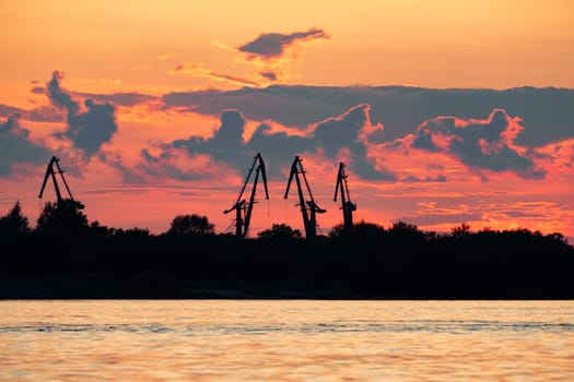 Sunset on the embankment of the Amur river in Khabarovsk. The sun set over the horizon. The embankment is lit by lanterns.