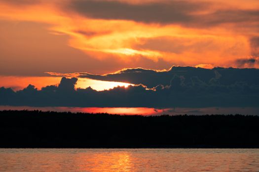 Sunset on the embankment of the Amur river in Khabarovsk. The sun set over the horizon. The embankment is lit by lanterns.