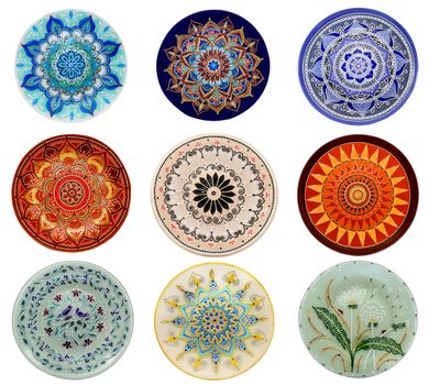 Set of decorative ceramic dishes hand-painted with acrylic paints floral pattern isolated on white background.