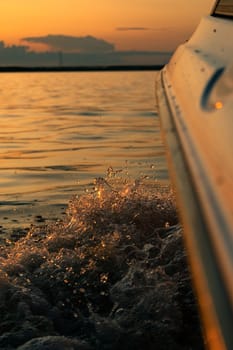 Splashes of water from the boat at sunset