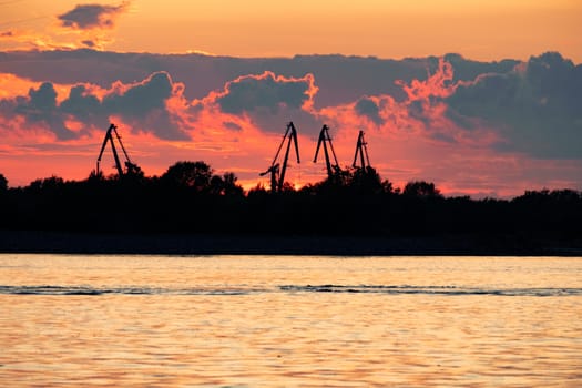 Sunset on the embankment of the Amur river in Khabarovsk. The sun set over the horizon. The embankment is lit by lanterns.