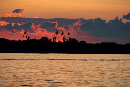 Sunset on the embankment of the Amur river in Khabarovsk. The sun set over the horizon. The embankment is lit by lanterns.