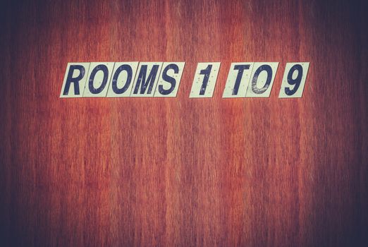 Grungy Retro Sign For Rooms On An Old Wooden Door At A Hotel, Motel, Boarding House, Hostel Or Bedsit