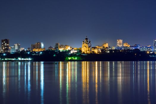 Night View of the city of Khabarovsk from the Amur river. Blue night sky. The night city is brightly lit with lanterns