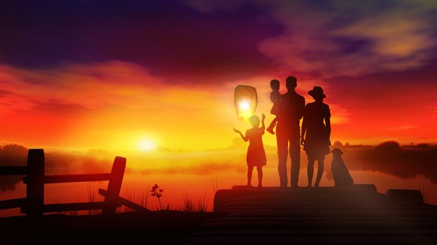 Family silhouettes standing against a red sunset and launching a Chinese lantern.