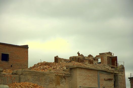 The ruins of an old brick building on a background of cloudy sky.