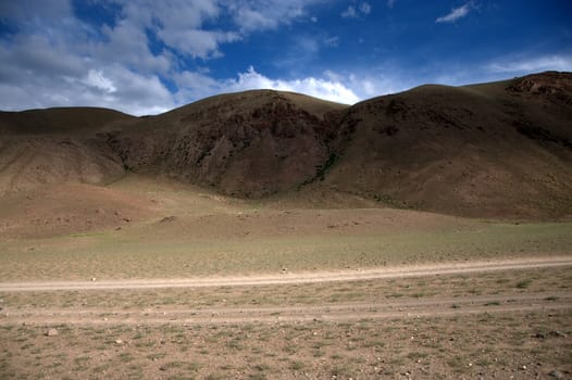 Scanty pasture at the foot of the red mountains. Martian landscapes of the tract Chagan-Uzun, Altai, Siberia, Russia.