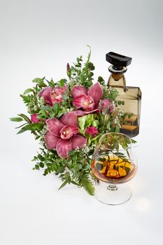 Bouquet of flowers and a bottle on a fabric background