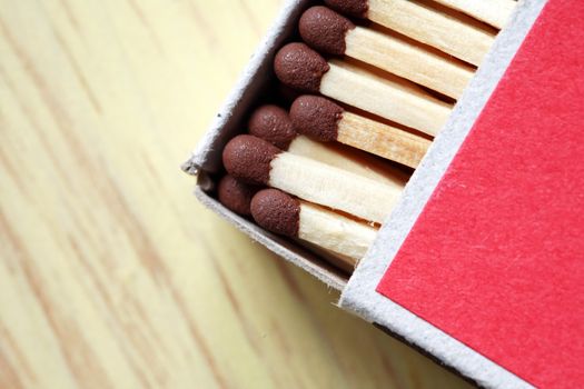 Extreme closeup of open cardboard matchbox on wooden background