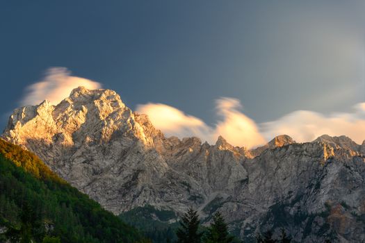 Cloudscape in sunset above mountain ridge, Kamnisko Savinske Alps, Ojstrica peak, Slovenia, outdoor hiking, tourism destination, view from Logarska valley