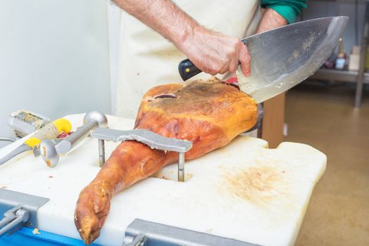 Close up of worker hands in the industrial process of cutting iberian ham