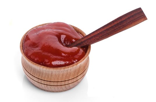 Ketchup in wooden bowl with spoon isolated isolated on white background with clipping path
