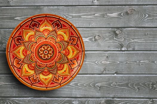 Set of decorative ceramic plates hand painted dot pattern with acrylic paints on a gray wooden background. Copy space