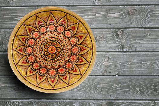 Set of decorative ceramic plates hand painted dot pattern with acrylic paints on a gray wooden background. Copy space