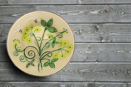 Set of decorative ceramic plates hand painted dot pattern with acrylic paints on a gray wooden background. Copy space