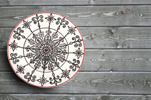 Set of decorative ceramic plates hand painted dot pattern with acrylic paints on a gray wooden background. Copy space