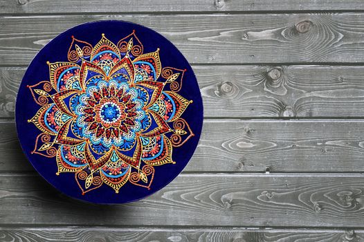 Set of decorative ceramic plates hand painted dot pattern with acrylic paints on a gray wooden background. Copy space