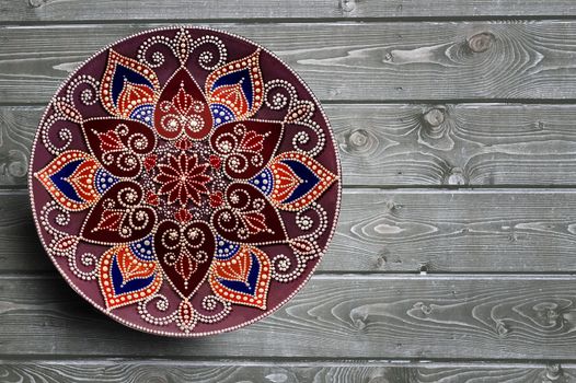 Set of decorative ceramic plates hand painted dot pattern with acrylic paints on a gray wooden background. Copy space