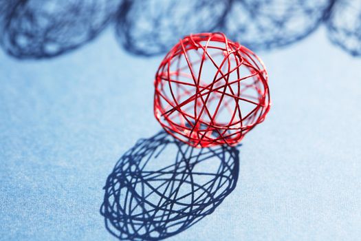 Set of red balls made from wire in a row against sun light