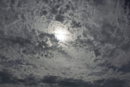 Clouds warn to rain soon. The sky was painted gray.Passenger plane between clouds