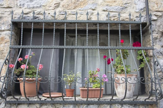 A stone house; A window decorated with flowers.