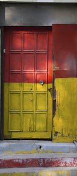 old door painted yellow and red. Neglected and worn
