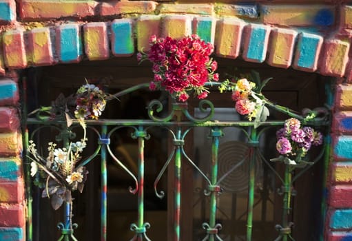 Window with colored bricks.The banisters are decorated with flowers.