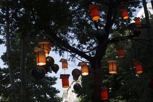 Adorned street trees. There are decorative balls, balloons, lamps and oil lamp