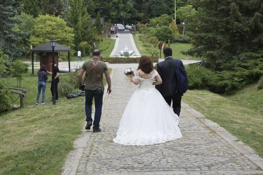 Bride, groom and photographer.They walk the whole forest together. For a beautiful moment of attraction