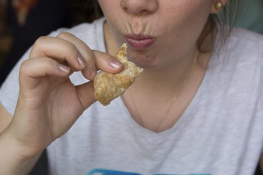 A mixture of minced meat, onion and spice is put in the opened yufkay and fried in oil. Crimean Tatar food.tatar food Eating woman