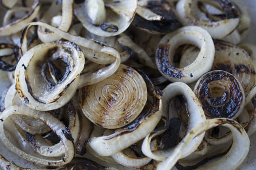 Cooked onion rings. The barbecue is also cooked.