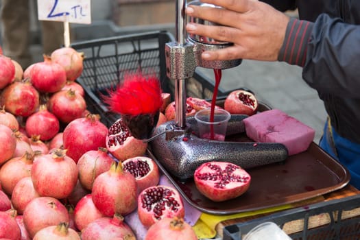 sale of fresh squeezed pomegranate juice to customers. dark red fresh pomegranate juice