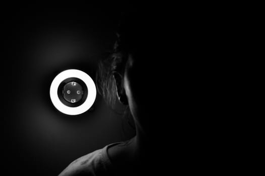 Lamp night light in a dark background. Vintage effect style picture. ring lamp. Neon light circle. the light takes the shape of a circle.the woman hiding in the dark. a symbol of violence for women