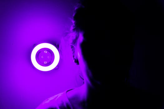 Lamp night light in a dark background. Vintage effect style picture. ring lamp. Neon light circle. the light takes the shape of a circle.the woman hiding in the dark. a symbol of violence for women