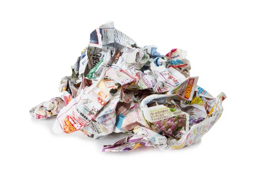 Large pile of colored crumpled Japanese newspapers isolated on a white background