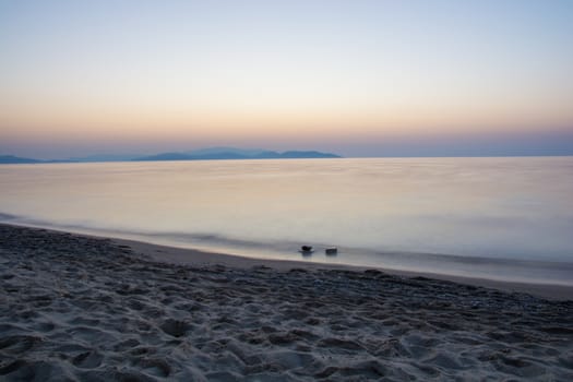 the sea has become silky. two rocks on the sea surface