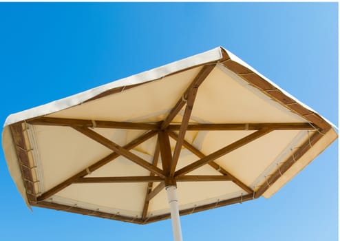 at the beach, looking at the sky from under the sun umbrella