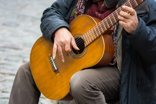 The street artist plays the guitar. making money with street music