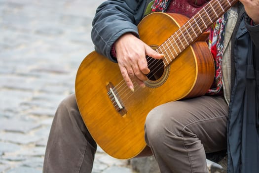 The street artist plays the guitar. making money with street music