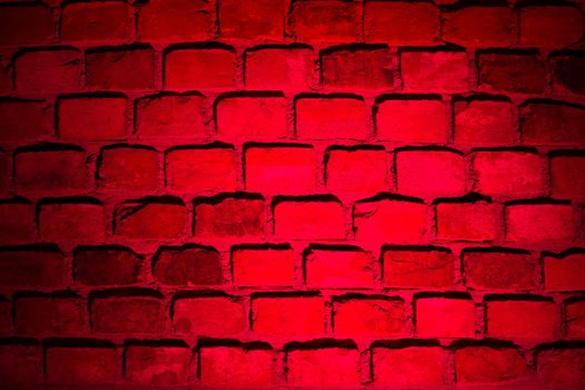 brick wall. red spotlight illuminates the wall in the dark
